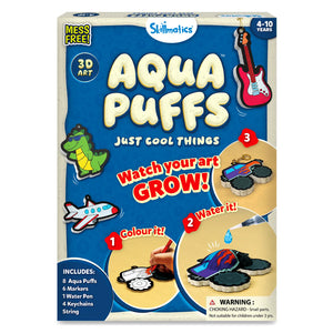 Front view of the Skillmatics Aqua Puffs activity kit box for ages 4–10, shown on a textured blue background. The title “Aqua Puffs” appears in large cream-colored letters with the subtitle “Just Cool Things.” Illustrated puff shapes include a rocket, guitar, sneakers, and a monster truck. Circular panels demonstrate three steps: coloring a foam shape, adding water with a pen, and watching the artwork expand into a raised 3D form.