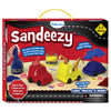 The Sandeezy box front shows jars of blue, yellow, and red kinetic sand, moulded vehicles including a red fire engine, a yellow crane truck, and a blue car base. Callouts highlight features like “Create 10+ unique vehicles,” “Sand holds tight,” and “Squish, Shape & Mould.” A “3–7 Years” badge is placed on top. The Skillmatics logo, warning label, road graphic, and included accessories like signs and wheels appear across the packaging.