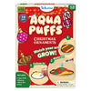 Skillmatics Aqua Puffs Christmas Ornaments 3D art kit packaging for ages 4-10. Shows festive ornament designs including bauble, gingerbread figure, teddy bear, candy cane, Santa, and striped ornaments. Includes steps to colour, add water, and watch art grow, with markers, water pen, string, and 8 Aqua Puffs.