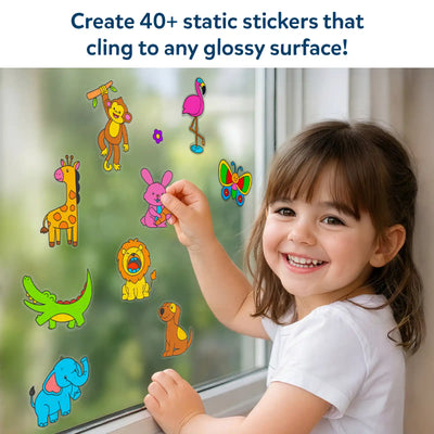 A young child smiles while placing colorful animal-themed static stickers on a glass window. Visible stickers include a giraffe, monkey, flamingo, butterfly, rabbit, crocodile, lion, elephant, and dog, all clinging without glue. Text above reads “Create 40+ static stickers that cling to any glossy surface,” emphasizing mess-free, reusable play on smooth surfaces like windows.
