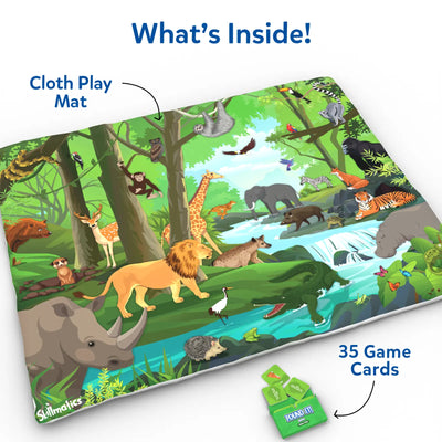 A flat-lay view of a colorful jungle-themed cloth play mat labeled “Cloth Play Mat,” showing detailed animal illustrations including a lion, elephant, giraffe, crocodile, tiger, sloth, birds, and forest scenery. A green Skillmatics Found It game box with multiple square game cards is displayed beside the mat under the heading “What’s Inside,” highlighting included components.