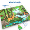 A flat-lay view of a colorful jungle-themed cloth play mat labeled “Cloth Play Mat,” showing detailed animal illustrations including a lion, elephant, giraffe, crocodile, tiger, sloth, birds, and forest scenery. A green Skillmatics Found It game box with multiple square game cards is displayed beside the mat under the heading “What’s Inside,” highlighting included components.