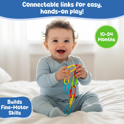 Smiling baby seated on a white bed holding several colorful Skillmatics Linkies connected together, demonstrating real-life use. The baby wears a light blue onesie and grips the links with both hands. Text on the image states “Perfectly sized for tiny fingers,” with an age indicator of 10–24 months and a callout noting fine motor skill development.