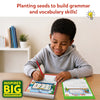 Smiling boy in gray hoodie writes with a red pencil on Sentence Sprouts worksheets while seated on an airplane. Open pages show My Dream Vacation and My Family themed activities. Badge reads Inspires Big Imaginations. Text: Planting seeds to build grammar and vocabulary skills.
