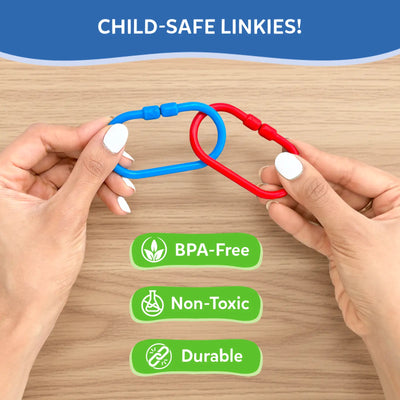 Close-up of adult hands holding two interlocked plastic links in blue and red over a wooden surface, demonstrating connection strength. Text reads “Child-safe Linkies,” with icons and labels below indicating BPA-free, non-toxic materials, and durable construction. The image focuses on safety, material quality, and secure linking design without showing a child.