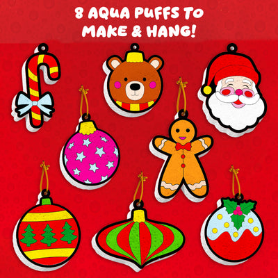 Skillmatics Aqua Puffs Christmas Ornaments graphic showing eight customisable 3D ornament designs on a red festive background. Includes candy cane, teddy bear, Santa face, gingerbread figure, star-pattern bauble, striped ornaments, and holly bauble, each with hanging strings for Christmas tree decoration.
