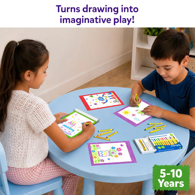 Two children sit at a round blue table using the Skillmatics Picture Sprouts activity book and retractable crayons to complete colorful drawings. Finished artwork, loose crayons, and the crayon box are spread across the table, showing a shared creative activity in a bright indoor play space.