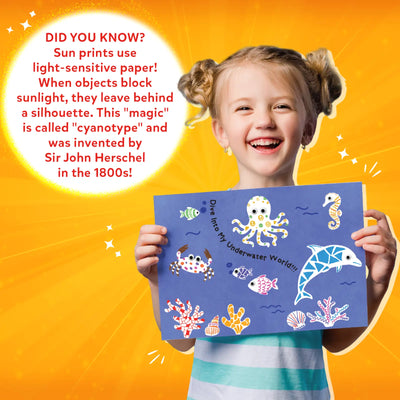 Young girl holding blue sun print with sea creatures from Magical Sun Art Kit