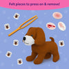 Skillmatics Vet Set showing a brown plush puppy surrounded by removable felt tick pieces, orange tweezers, and reusable injury patches representing bruises, cuts, scratches, and rashes. Children can attach and remove the felt pieces during imaginative pretend veterinary play.