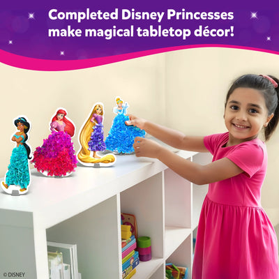 Young girl placing her completed Disney princesses on a book shelf as home decor