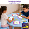 Two children sit at a round blue table using the Skillmatics Picture Sprouts activity book and retractable crayons to complete colorful drawings. Finished artwork, loose crayons, and the crayon box are spread across the table, showing a shared creative activity in a bright indoor play space.