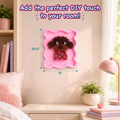 Styled interior room scene showing a finished Stixels puppy wall décor mounted on a beige wall inside a pink framed base. Text reads ‘Add the perfect DIY touch to your room!’ with dimension markers 10.6” height and 9” width, highlighting compact decorative 3D craft for kids’ rooms.