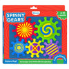 Skillmatics Spinny Gears Pattern Pop toy box shown at an angle on a red background. Five interlocking gears displayed: red sunburst, green blue-yellow spiral, blue concentric circles, yellow with purple cross, and purple with yellow stripes. Labels read 