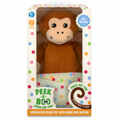 A boxed interactive monkey plush toy is shown inside cream-colored packaging decorated with multicolored dots. The large brown monkey is visible through a clear window, holding a polka-dotted cloth. Labels on the box highlight “Battery Operated” and “12+ Months.” A tail-shaped graphic says “Press my tail to play peek-a-boo!” and the bottom panel reads “Interactive plush toy with audio and motion.”