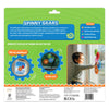 Back of Skillmatics Spinny Gears Animal Fun 5-gear box on green background. Includes product description and skills: Fine Motor Skills, Hand-eye Coordination, Problem Solving, and Spatial Reasoning. Shows animal gears on airplane and car windows. A smiling boy sticks colorful animal gears to a window. Bottom has safety certifications, barcode, and manufacturer details.
