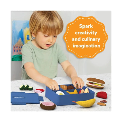 Child playing with Bento Box Blue pretend lunchbox set filled with colorful play food