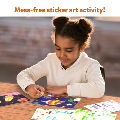 Young child creating colorful space-themed sticker art with Dot it! Outer Space kit