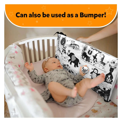 Baby lying in crib with high contrast black and white illustrated bumper on Sensory Cloth Mat