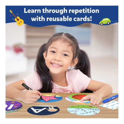 Smiling young girl with pigtails drawing on reusable learning cards for toddlers